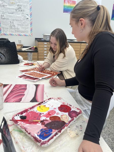 Learning from one another. Students take notes and critique their paintings to make them the best that they can be. 