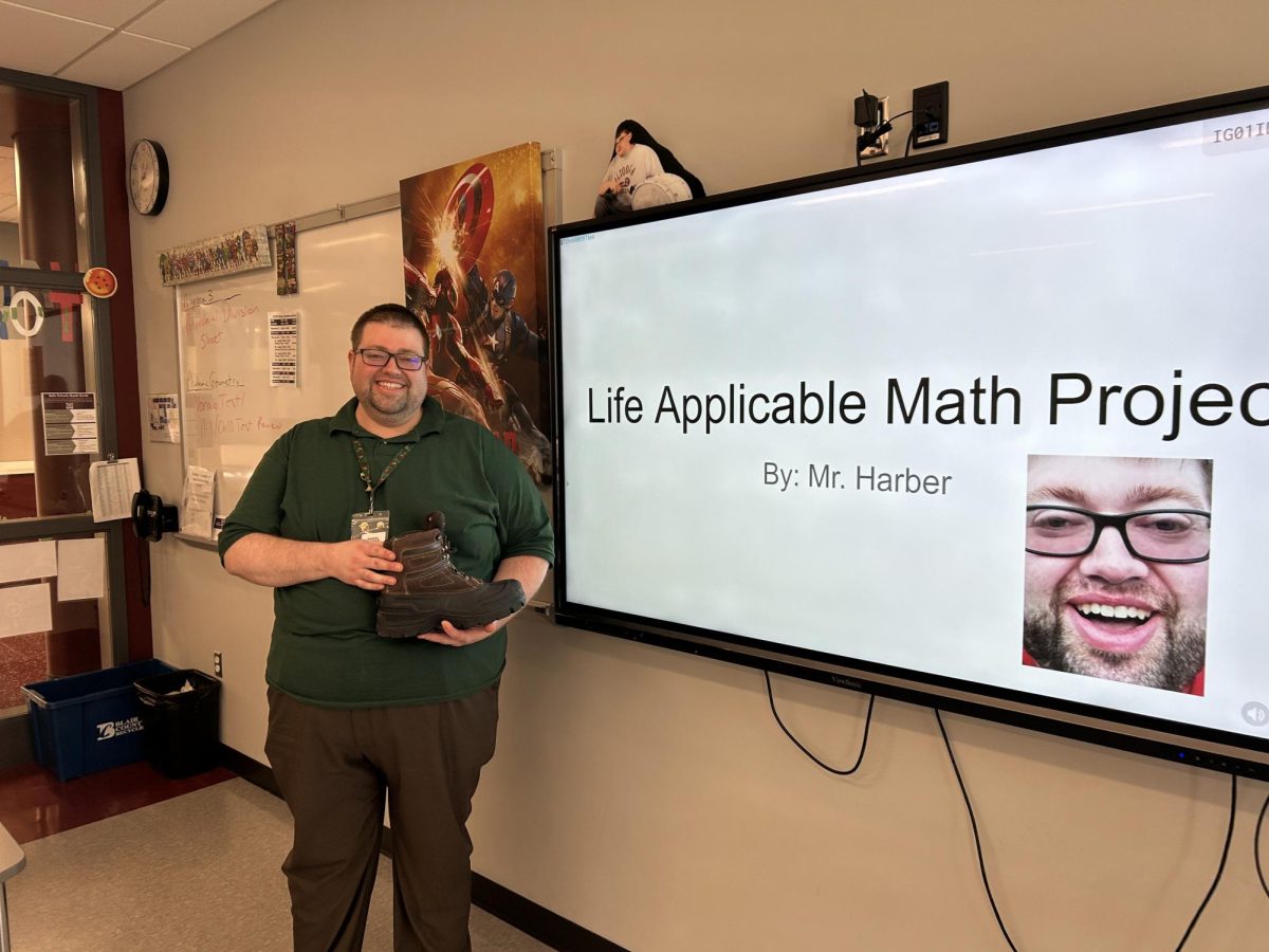Master of math. Daniel Harber stands in front of his class presenting his own Life Applicable Math Project. Harber created this as an example to show his students what to do.