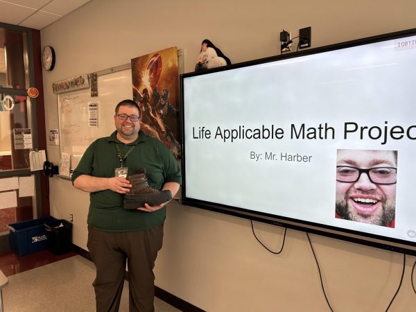 Master of math. Daniel Harber stands in front of his class presenting his own Life Applicable Math Project. Harber created this as an example to show his students what to do.