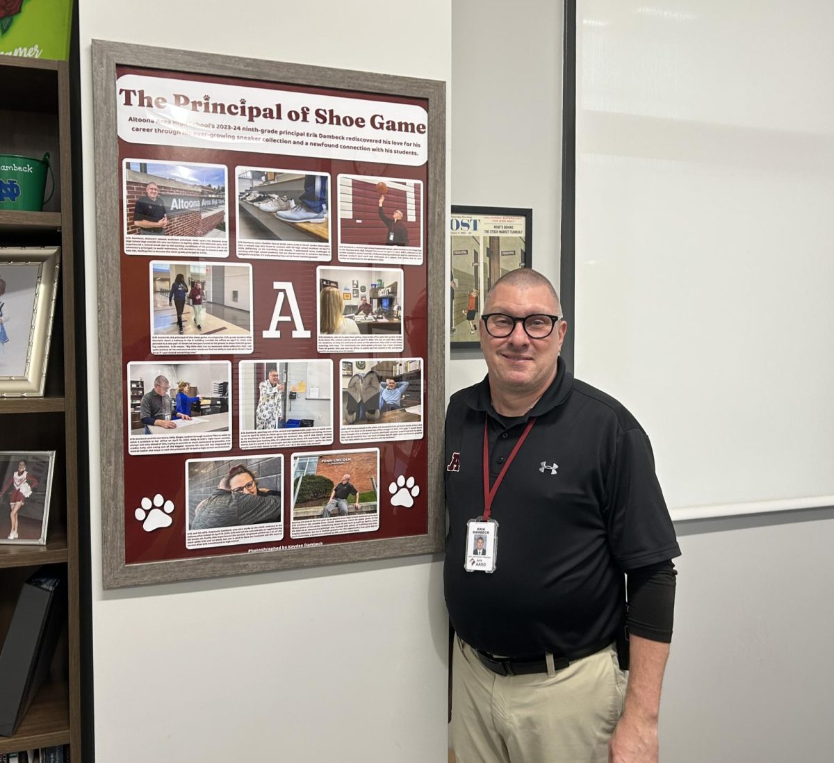 Proud. Assistant principal Erik Dambeck poses with a poster in his office. This poster details his journey with shoes and how they contribute to his personality.