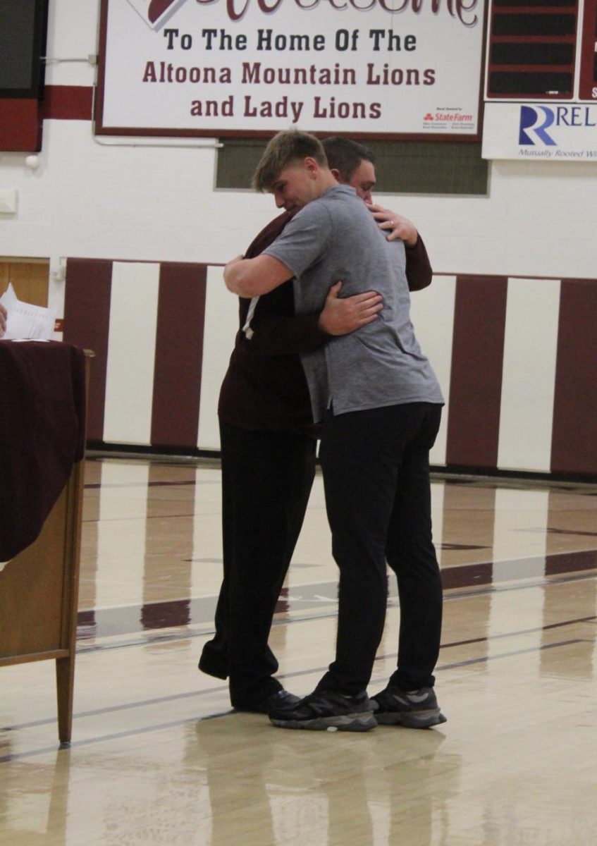 Welcoming embrace. Football coach Vince Nedimyer hugs Mark Harrington as he is awarded the Blanket Award for his leadership and hard work. 