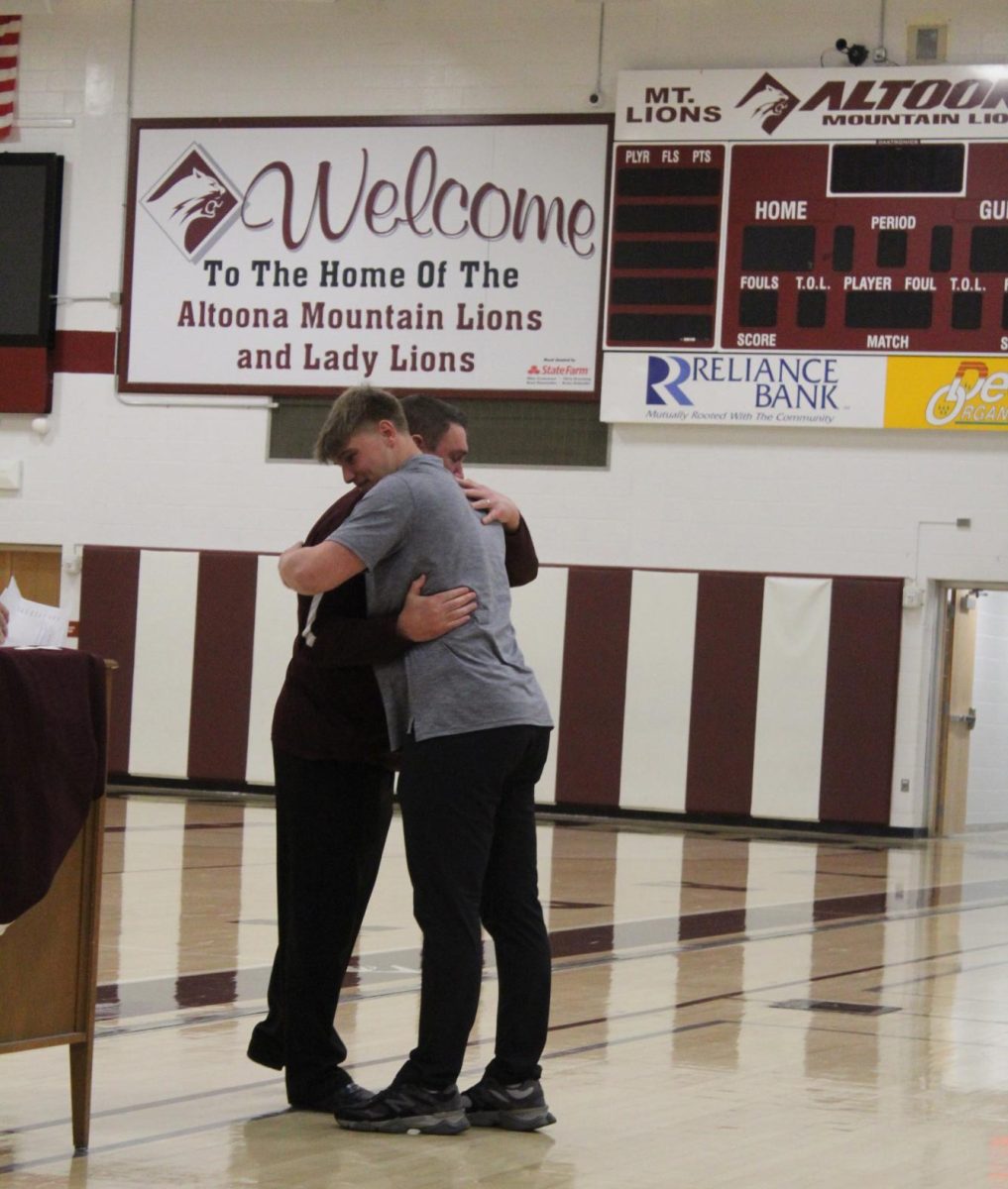 Welcoming embrace. Football coach Vince Nedimyer hugs Mark Harrington as he is awarded the Blanket Award for his leadership and hard work. 