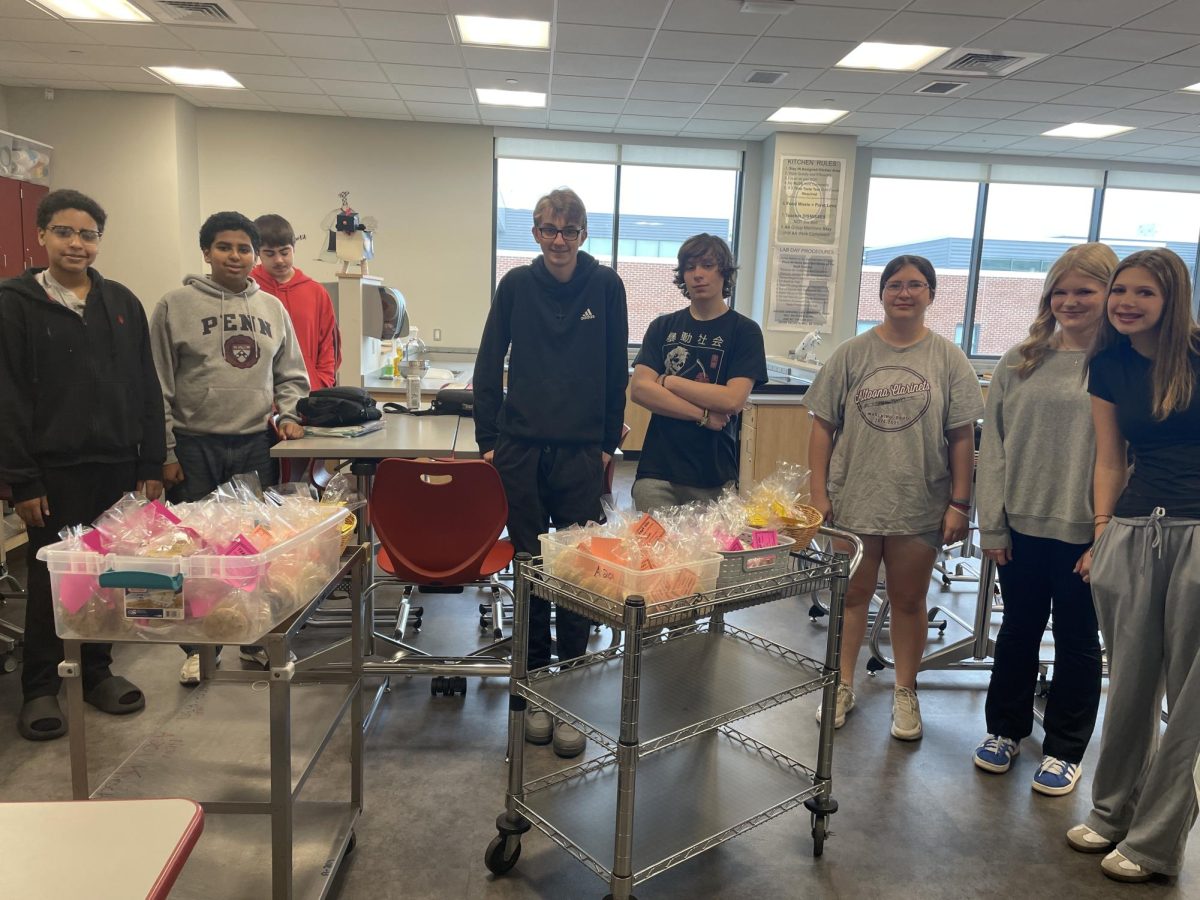 Jill Trumpbour's homeroom prepares cookies to distribute to teachers. Senior mentors helped them to brainstorm this undertaking. 