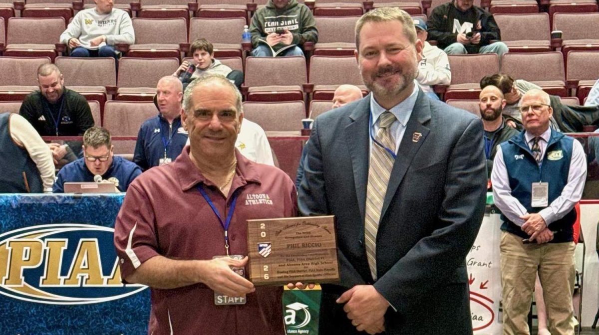 Making history.  Athletic Director Phil Riccio is presented with the NFHS Outstanding Service award prior to the State Wrestling Semi finals.  Riccio was presented the award by PIAA executive director Mark Beyers.