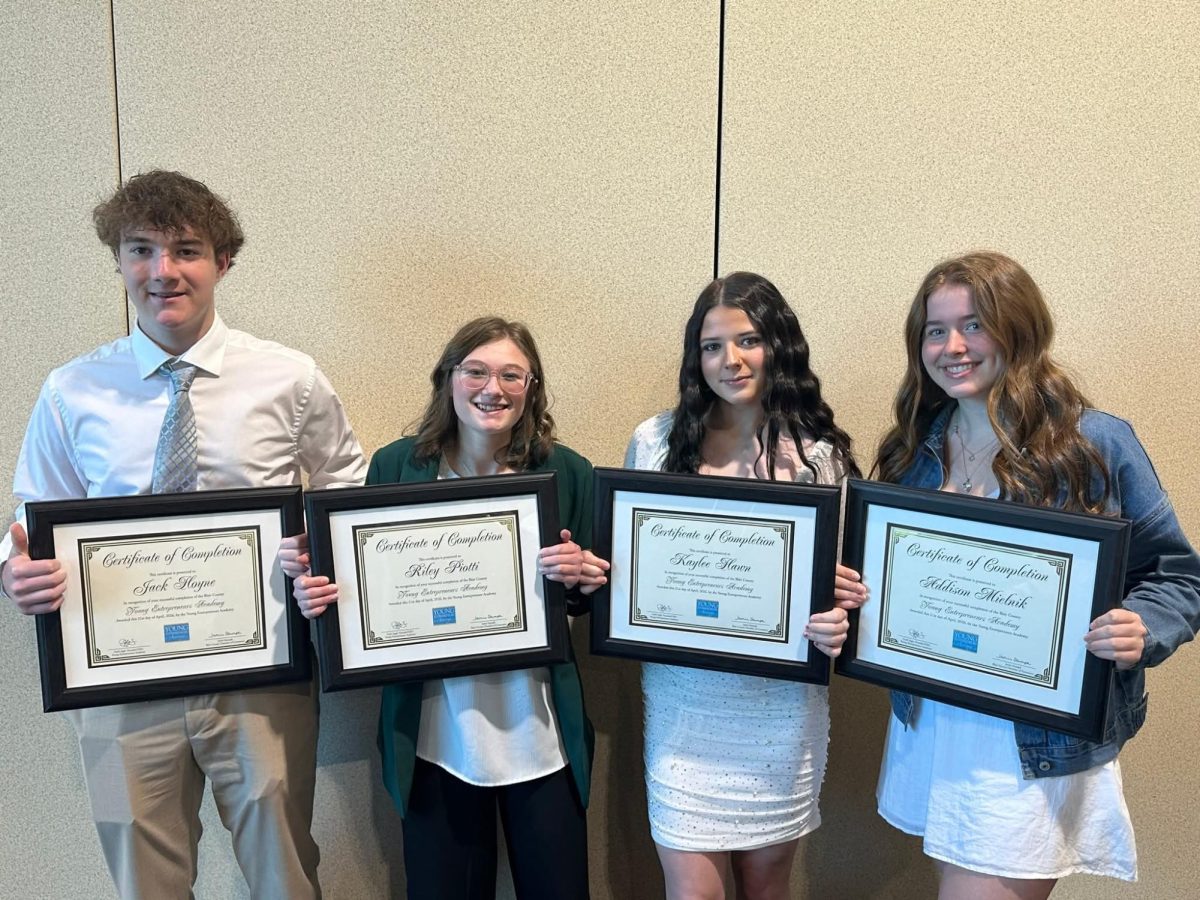 Juniors Addison Melnik, Riley Piotti, Kaylee Hawn, and Sophomore Jack Hoyne all graduated from the YEA program and pose for a photo holding their certificate.