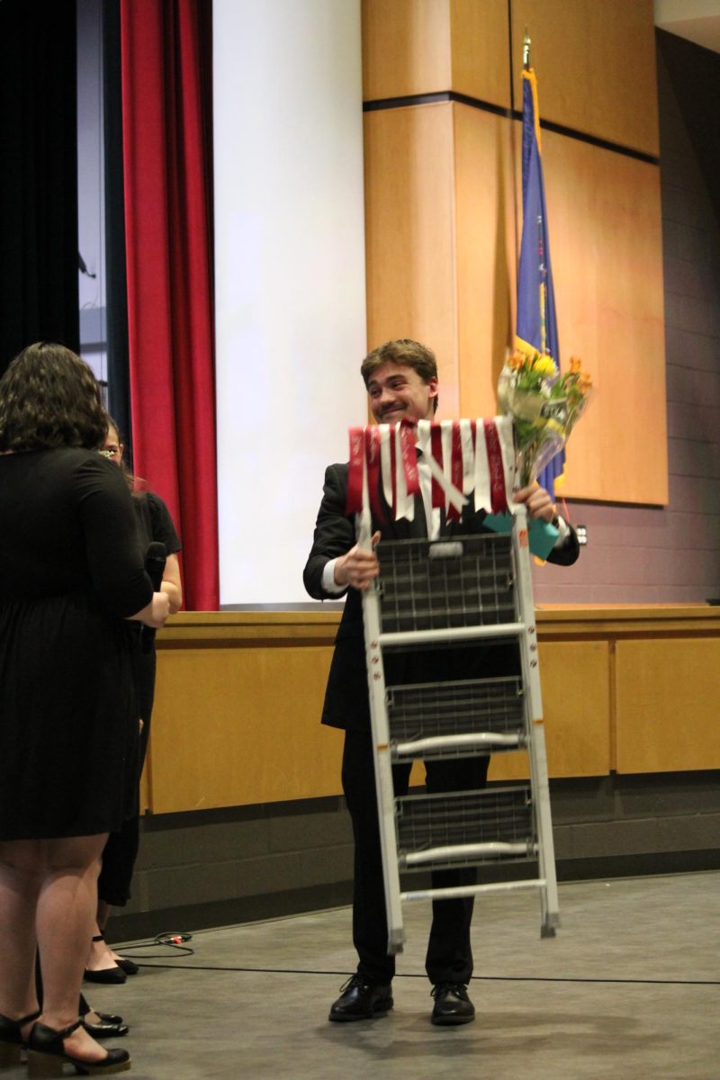 Surprise. The seniors from band surprise Brandon Kunder with a step stool. This gift began as a joke during the seniors' freshman year. The last concert they made the joke a reality.